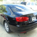 Before and after photographs of a damaged black Volkswagon Jetta that was repaired by Elite Paint & Body Shop in West Palm Beach, Florida.